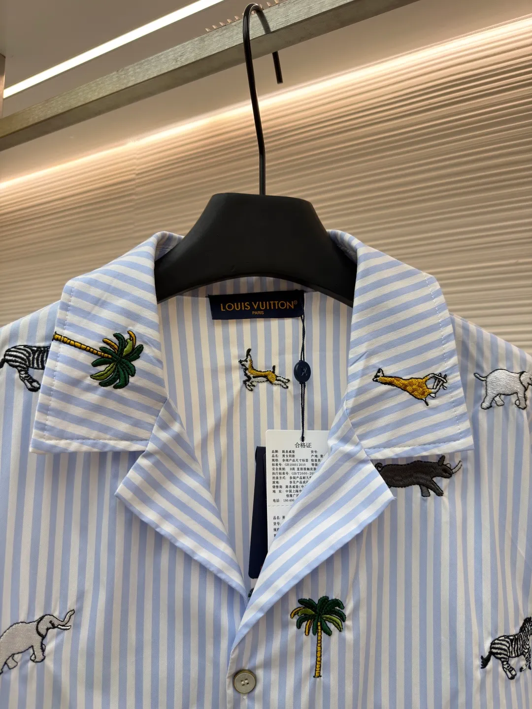 LOUIS VUITTON nostalgic style embroidered striped short-sleeved shirt with animals and plants ●Original version: Purchased and developed by 16815 ●Item number: 1682514-A65 ●Fabric: cotton fabric ●Technology: embroidery production ●Color: blue ●Version: fitted version ●Weight: about 220 grams ●Size: S-M-L-XL ●Description: This LOUIS VUITTON striped animal embroidery short-sleeved shirt is made of high-count pure cotton poplin fabric. After pre-washing process, it feels smooth and breathable. It has both drape and stiffness, and is not easy to wrinkle and deform. The blue and white vertical stripes on the body are woven with yarn-dyed technology, and the texture is clear and does not fade. The animal and coconut tree patterns are presented with sophisticated embroidery technology. The embroidery threads are full of color and the stitches are dense. The patterns are three-dimensional and vivid, forming a rich visual hierarchy with the stripe base. The shirt has a Cuban collar style, with smooth necklines, custom mother-of-pearl buttons at the placket, and a warm texture. The overall shape is loose, the shoulder joints are straight and fine, the cuffs are cuffed with exquisite craftsmanship, custom accessories and three logos are complete, and the details are full of luxury craftsmanship. It is suitable for casual vacations and daily outings, etc. The overall wiring is straight and delicate, the fabric is comfortable and soft, and the color is consistent without color difference. It can be matched with the same style to create a fashionable look and control various occasions. Customized accessories, complete with three standards, same style for men and women!